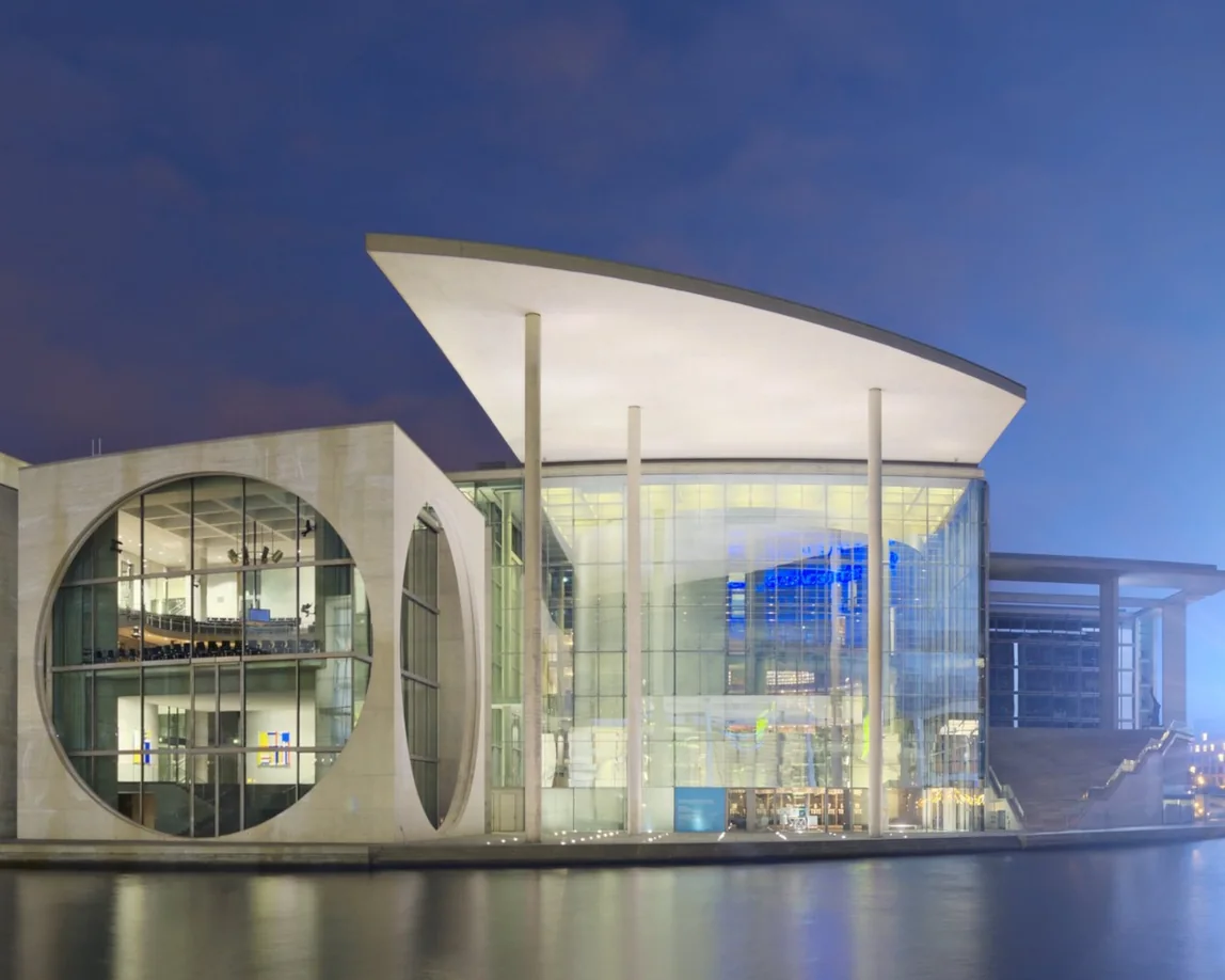 Modern glass architecture at dusk, reflected in water